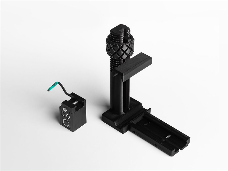 The TRIQ Mini module next to an underbody Picatinny mount.