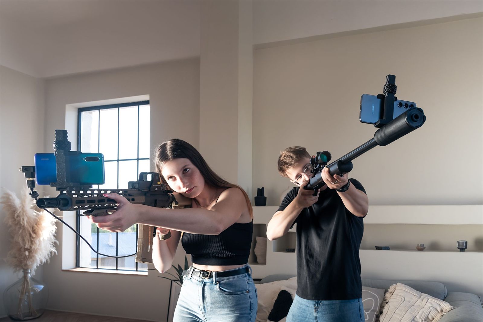 Two people training indoors, each with a phone mounted to their platform.